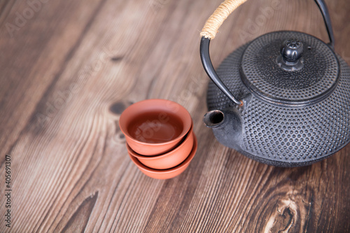 Black teapot and small tea bowl on the table