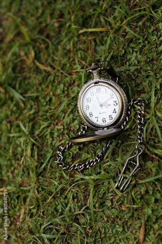 a vintage pocket watch on green grass