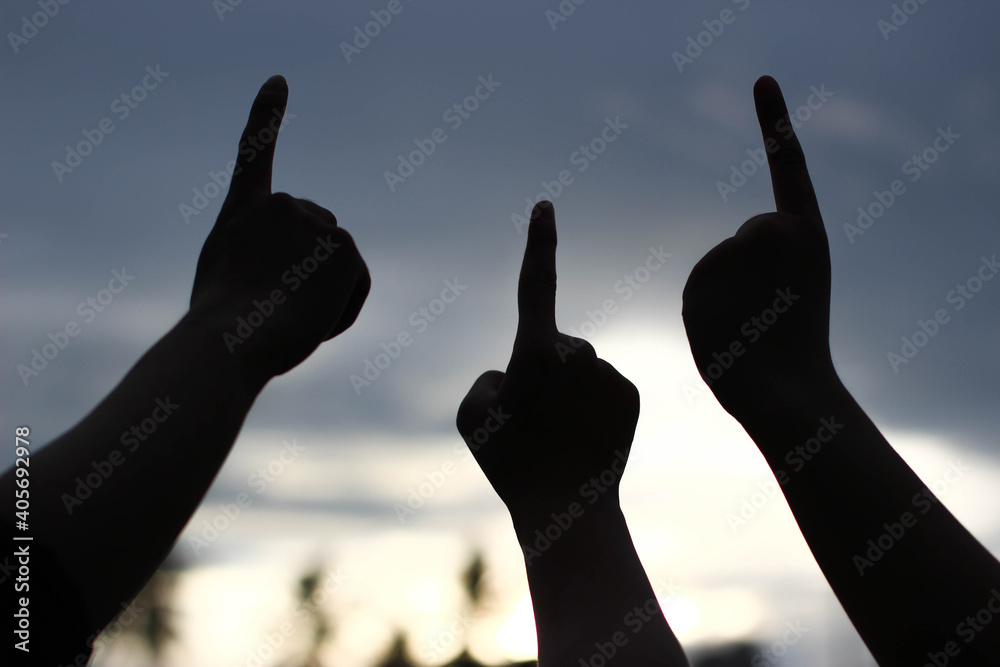 silhouette of three hand pointing up