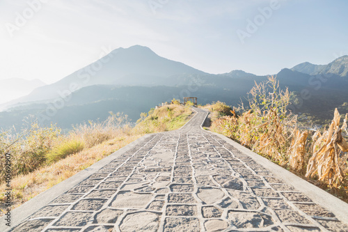 Road in the middle of the mountain top with view to the volcanoes and mountains in San Juan la Laguna in Guatemala at sunrise - landscape of volcanoes and mountains with the first rays of sun photo