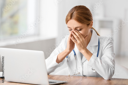 Stressed female doctor sitt...