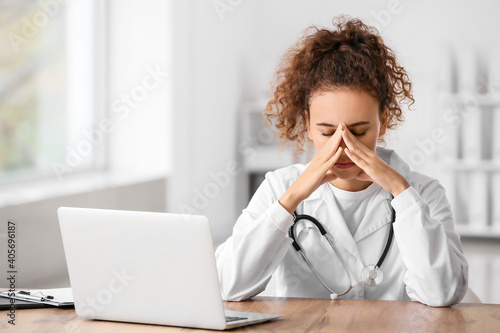 Stressed female doctor sitt...