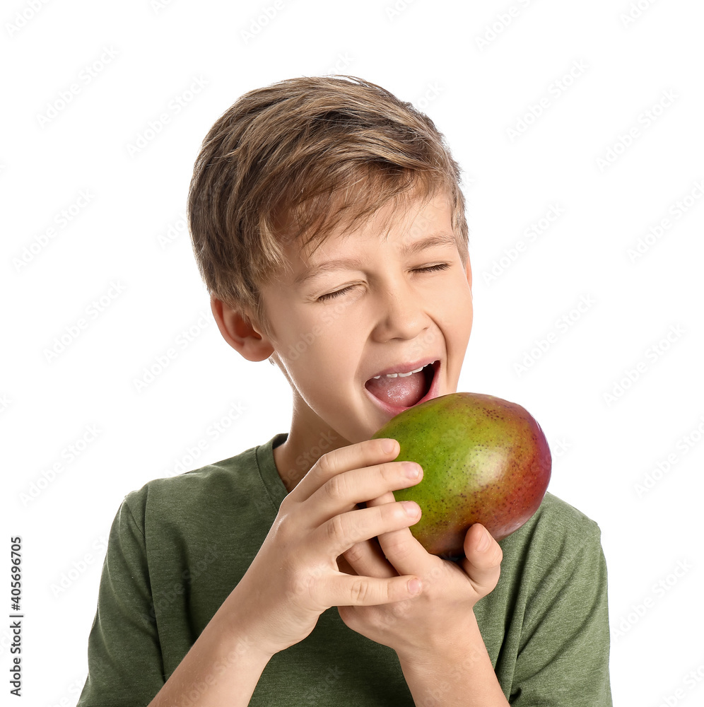 Cute little boy eating fresh tasty mango on white background Cute little boy eating fresh tasty mango on white background