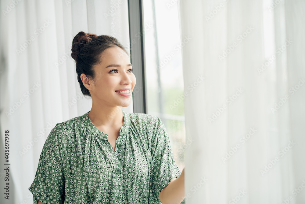 Woman Standing By living room Window And Opening Curtains Woman Standing By living room Window And Opening Curtains