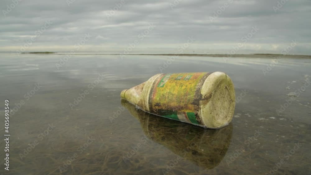 Old bleach container disccarded in ocean Old bleach container disccarded in ocean