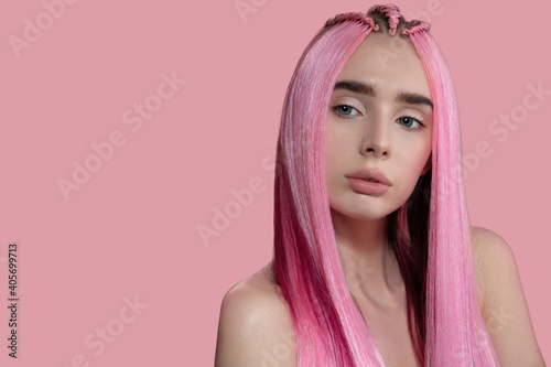 woman with dyed pink straight hair. Pink background. copycpase