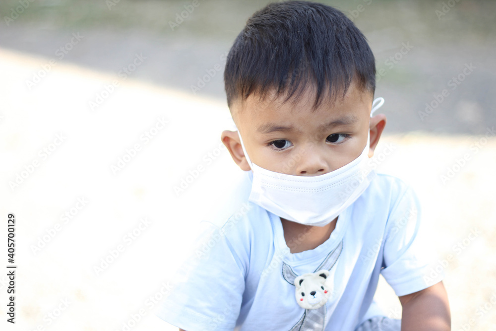 Asia boy wearing facial mask for protect corona virus and air pollution pm2.5 with blurred background. Wuhan coronavirus. Covid-19, pm2.5 and health care concept. Asia boy wearing facial mask for protect corona virus and air pollution pm2.5 with blurred background. Wuhan coronavirus. Covid-19, pm2.5 and health care concept.