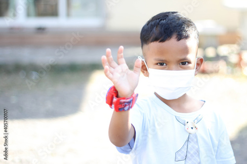 Asia boy wearing facial mask for protect corona virus and air pollution pm2.5 with blurred background. Wuhan coronavirus. Covid-19, pm2.5 and health care concept.