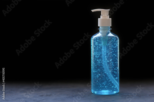 Blue alcohol gel bottle on black background.