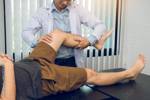 Physiotherapists are using the hands to grip the patient thigh to check for pain and massage in the clinic. photo