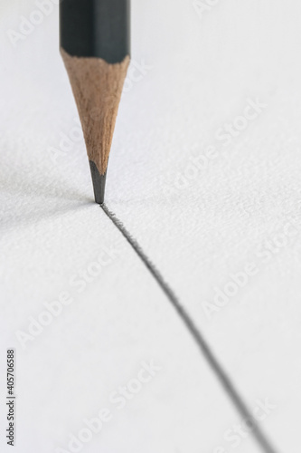 a graphite pencil draws a gray line