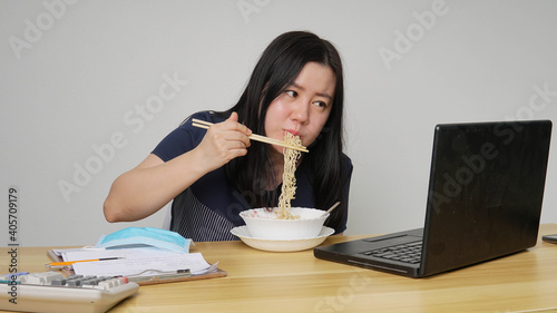 Asia women business executive eating noodle soup at her workplace