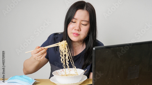 Asia women business executive eating noodle soup at her workplace