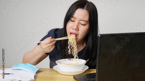 Asia women business executive eating noodle soup at her workplace