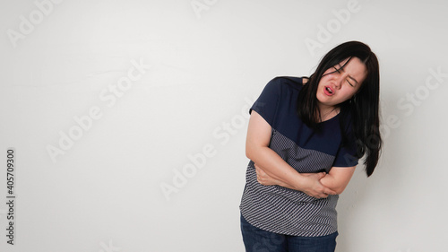 Asian woman unhappy looking sick, suffers from stomach ache stomachache isolated white background because of menstruation and eating spoiled food, Chronic gastritis. Abdomen bloating concept