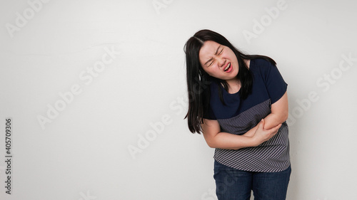 Asian woman unhappy looking sick, suffers from stomach ache stomachache isolated white background because of menstruation and eating spoiled food, Chronic gastritis. Abdomen bloating concept