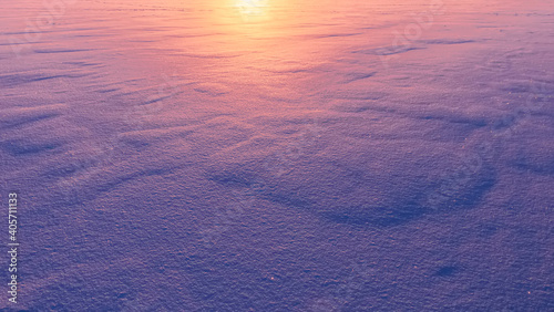 Fototapeta Naklejka Na Ścianę i Meble -  beautiful blue and purple colored snow field surface illuminated by evening sunset , violet snow texture , original winter background