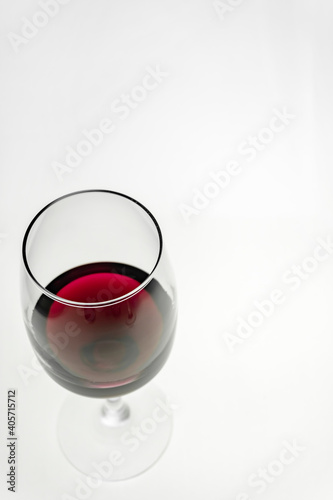 Vertical shot. A glass of red wine on a light background. 