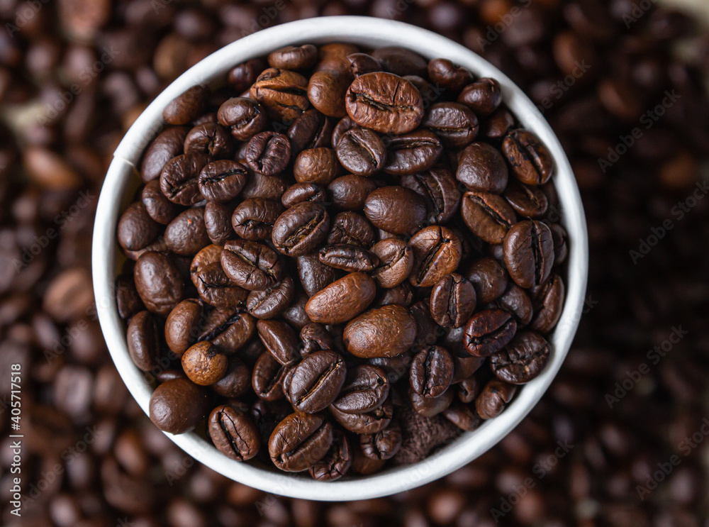 Fototapeta premium Takeaway coffee recycle cup with roasted coffee beans on coffee beans background. Top view. Close up.
