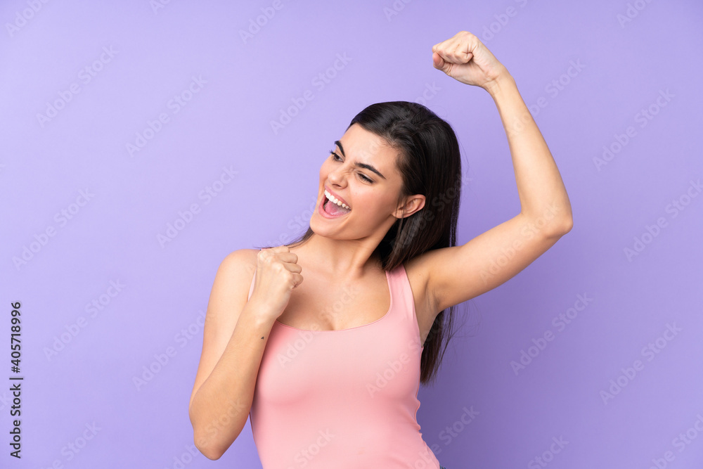 Young woman over isolated purple background celebrating a victory Young woman over isolated purple background celebrating a victory