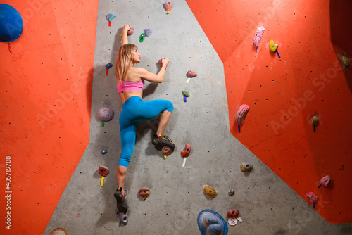 Beautiful Woman Climber Bouldering in the Climbing Gym. Extreme Sport and Indoor Climbing Concept
