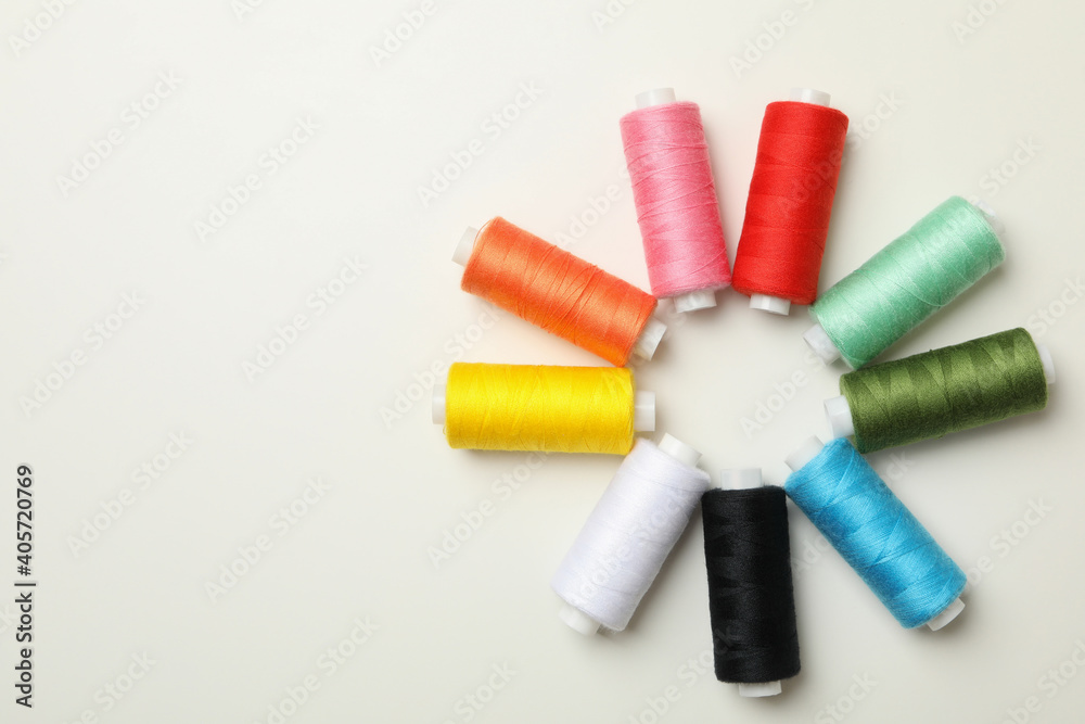 Color sewing threads on white background, top view Color sewing threads on white background, top view