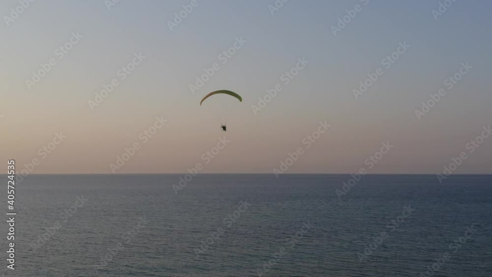 Paraglider in flight at Sunset by Haifa Mediterranean coastline, Aerial view. Paraglider in flight at Sunset by Haifa Mediterranean coastline, Aerial view.