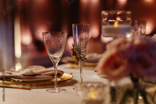 Champagne and wine glasses on the blurred background. Place for your text. Table setting in the restaurant © Maksym