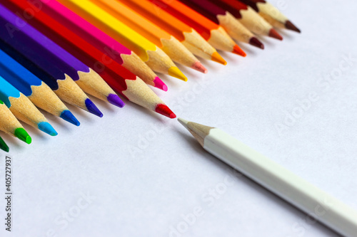 White and red pencils are opposed to each other. Lots of colored pencils in a row. photo