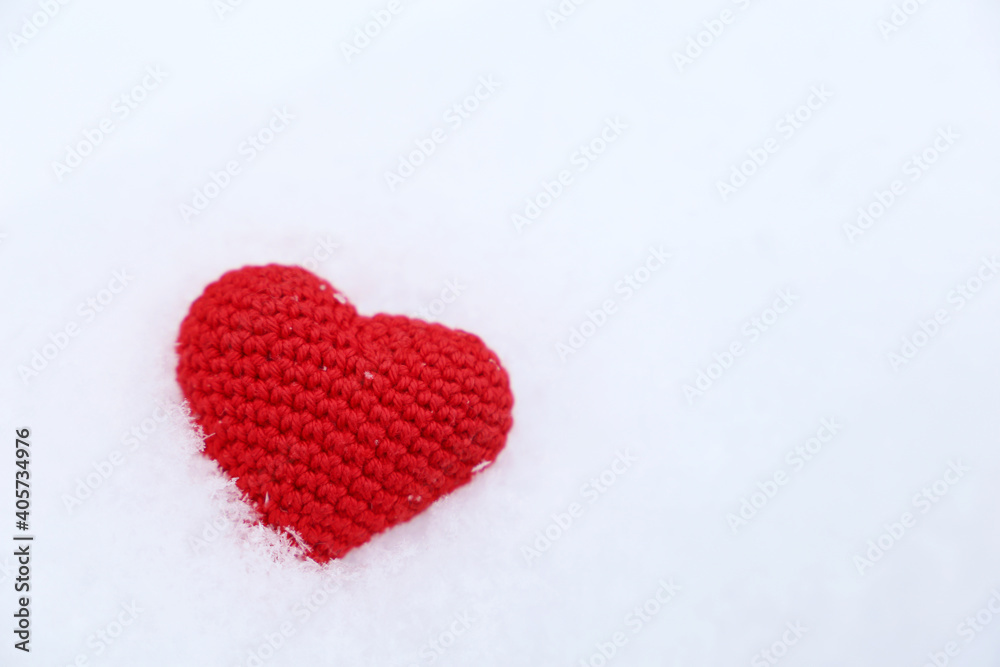 Valentine heart in a snow. Red knitted symbol of love, background for winter holiday