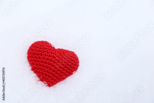 Valentine heart in a snow. Red knitted symbol of love  background for winter holiday