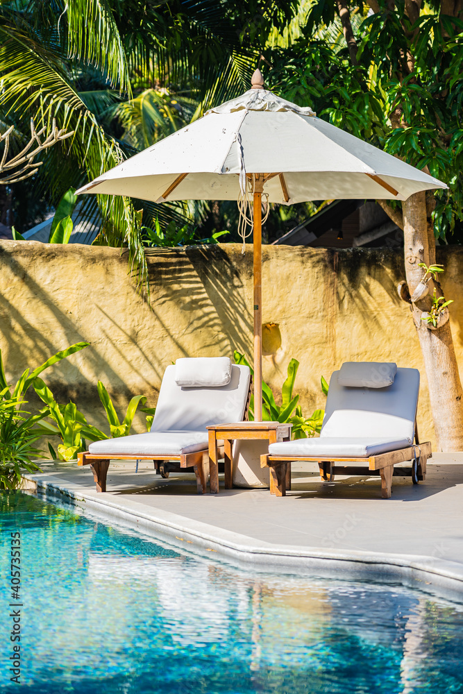 Umbrella and chair around outdoor swimming pool Stock Photo | Adobe Stock