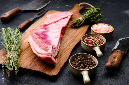 Fototapete Raw lamb breast and flap on wooden cutting board with herbs and seasoning