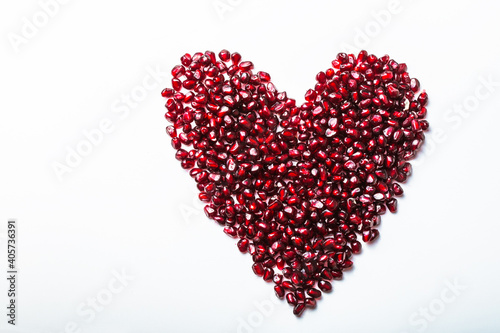 Heart shape pomegranate seeds on white background.  Valentines helthy love concept.
