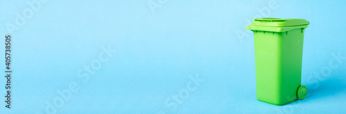 Green dustbin on a blue background. Recycling. Materials for recycling and reuse on a blue background. Ecological concept, many recyclable objects in containers photo