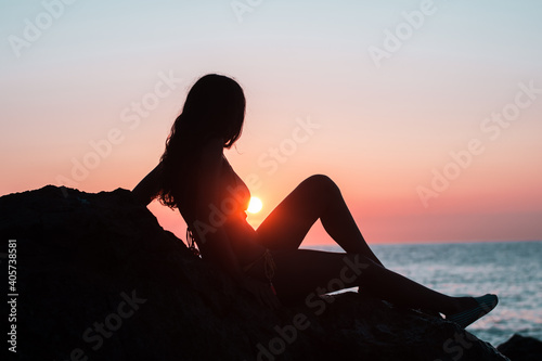 Silhouette of a girl on the beach during sunrise