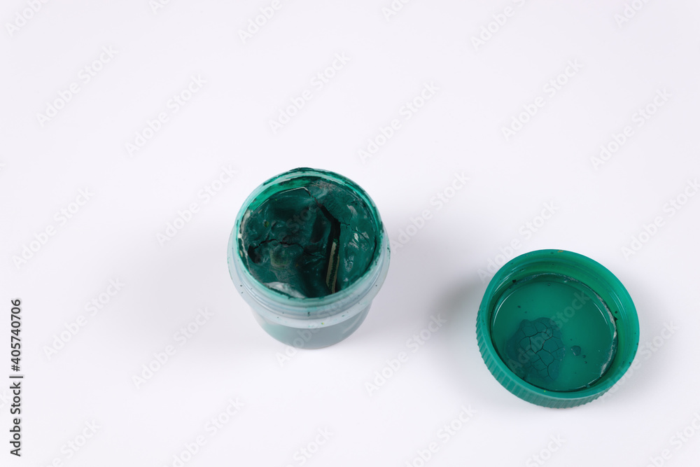 Green jar of gouache open and next to the lid from it top view Green jar of gouache open and next to the lid from it top view