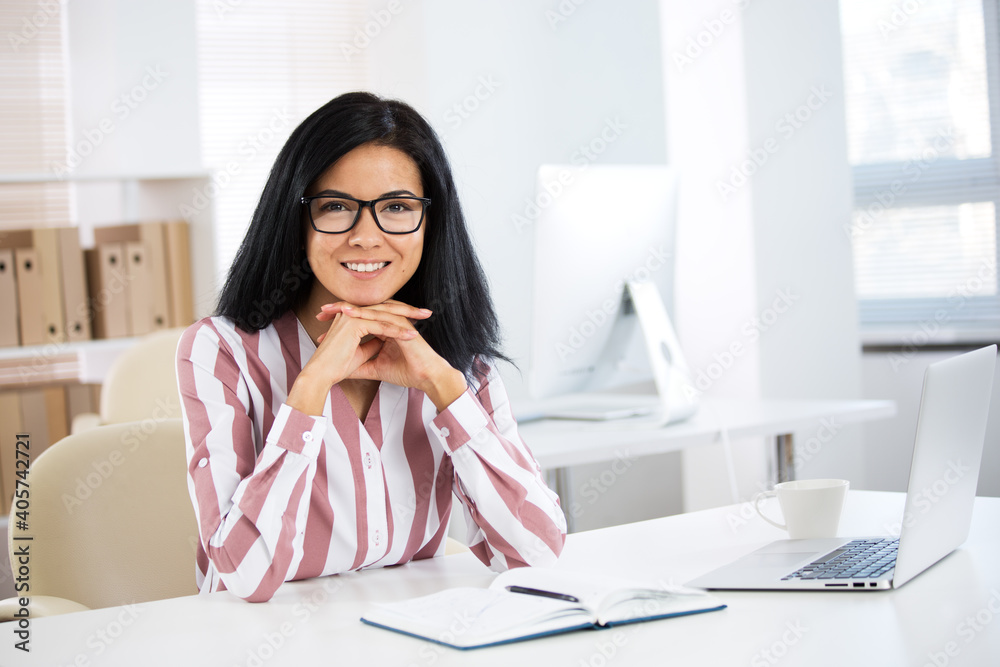 Portrait of a business woman with glasses at workplace in office Portrait of a business woman with glasses at workplace in office