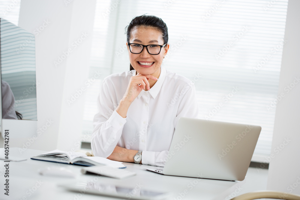 Asian business woman smiling at camera in an office Asian business woman smiling at camera in an office
