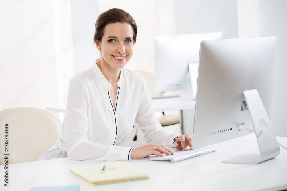 Portrait of business woman looking at camera at workplace in an office Portrait of business woman looking at camera at workplace in an office