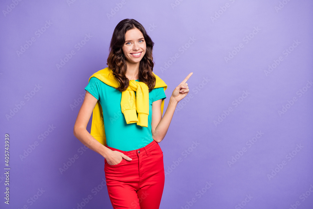 Photo of charming wavy young woman dressed pullover shoulders pointing finger empty space isolated purple color background Photo of charming wavy young woman dressed pullover shoulders pointing finger empty space isolated purple color background