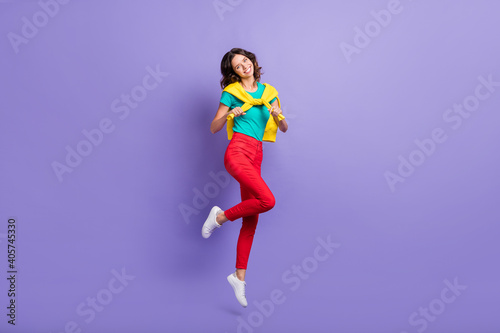 Full length body size view of lovely cheerful wavy-haired girl jumping having fun isolated over violet pastel color background © deagreez