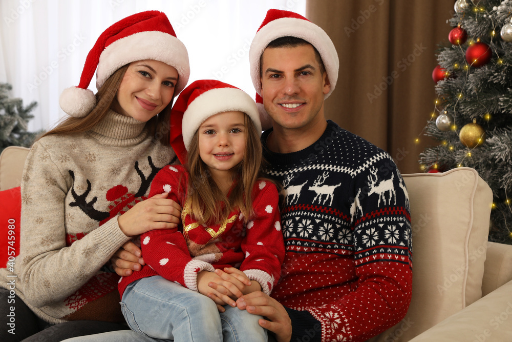 Happy family in Santa hats near Christmas tree at home Happy family in Santa hats near Christmas tree at home