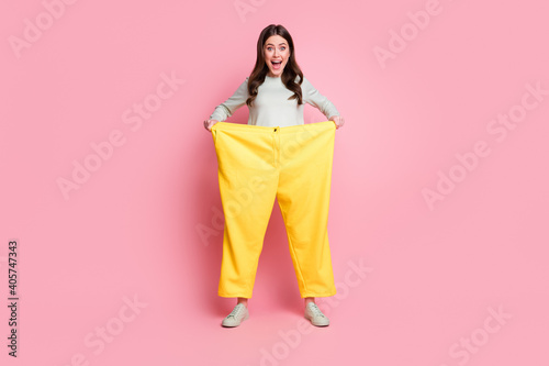 Full length portrait of funky playful person open mouth wear too big pants isolated on pink color background photo