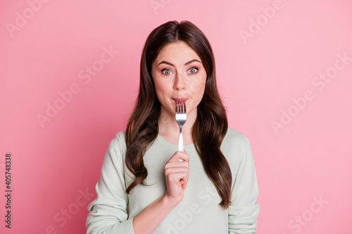 Portrait of adorable curly hairstyle lady biting lick fork smile isolated on pastel pink color background