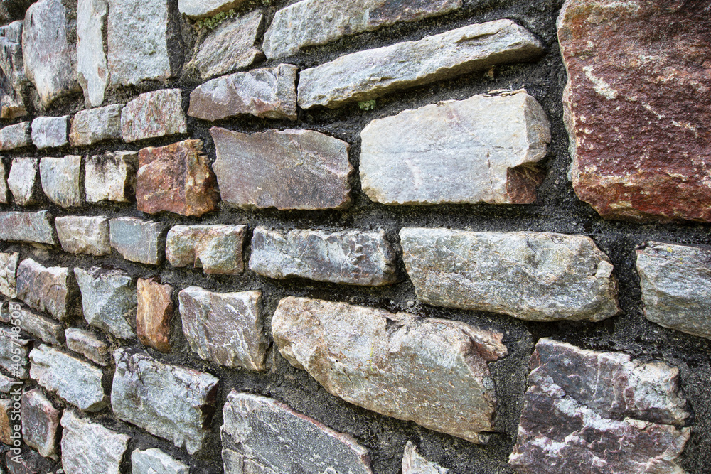 Naklejka premium Stone wall textured background at an angle