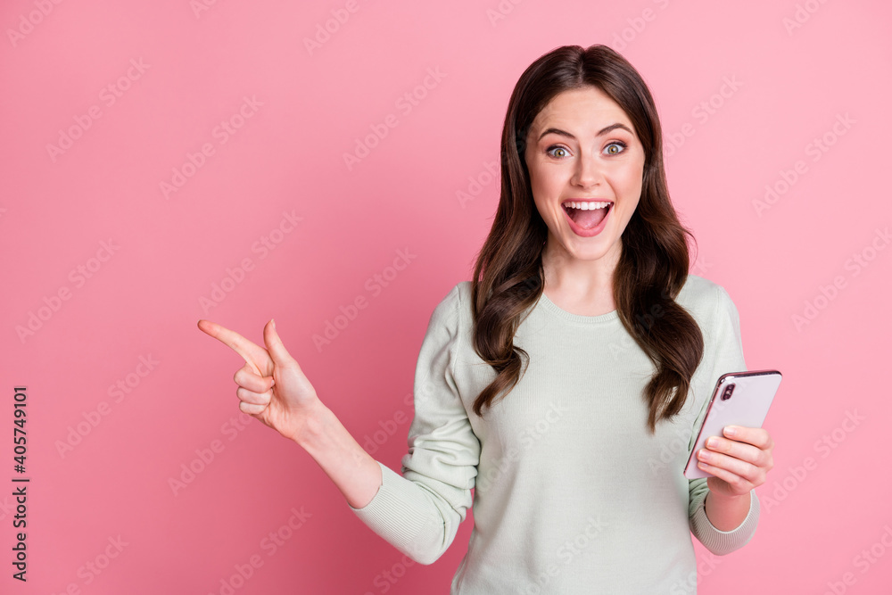 Portrait of astonished wavy hairdo lady direct finger empty space open mouth wear grey style isolated on pink color background Portrait of astonished wavy hairdo lady direct finger empty space open mouth wear grey style isolated on pink color background