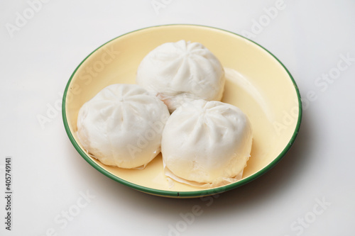 Close up a plate of steamed BBQ pork bun "Baozi" isolated on white background, traditional Chinese food.