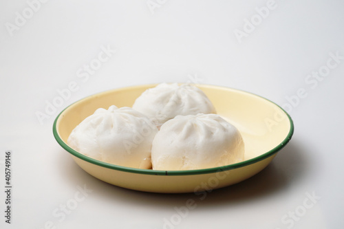 Close up a plate of steamed BBQ pork bun "Baozi" isolated on white background, traditional Chinese food.