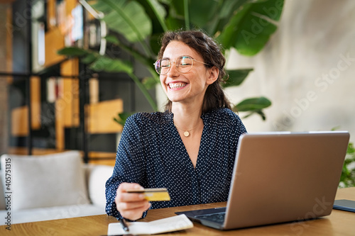 Woman with laptop using credit card photo